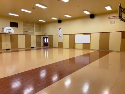 large gymnasium with shiny floors, accreditation banner hanging on far wall